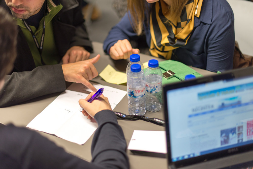 Equipo trabajando con portátil y notas en una mesa compartida